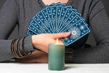 Falcı tarot kartları destesini gösteriyor.