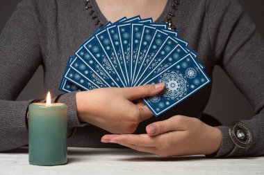Kadınların elindeki tarot kartlarından oluşan deste....