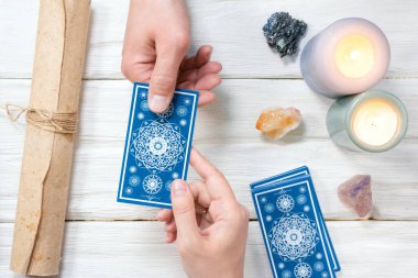 Falcı kartlarındaki tarot kartları beyaz ahşap masa arkasında. Gelecek okuma.