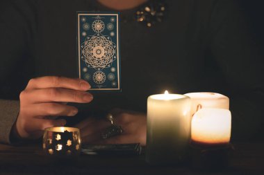 Falcı, mum ışığında tarot kartlarıyla geleceği okuyor..