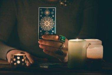 Falcı, mum ışığında tarot kartlarıyla geleceği okuyor..