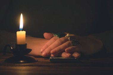 Falcı, mum ışığında tarot kartlarıyla geleceği okuyor..