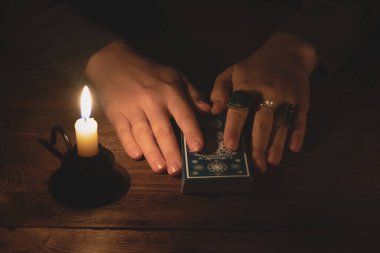 Falcı, mum ışığında tarot kartlarıyla geleceği okuyor..