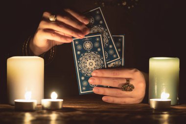 Elinde tarot kartları olan falcı yakın çekim yapıyor. Gelecek okuma konsepti.