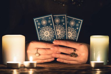 Elinde tarot kartları olan falcı yakın çekim yapıyor. Gelecek okuma konsepti.