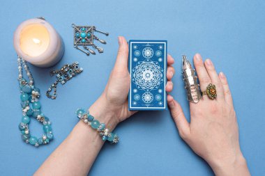 Falcı elinde tarot kartları tutuyor..