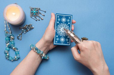 Falcı elinde tarot kartları tutuyor..