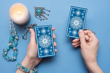 Falcı elinde tarot kartları tutuyor..