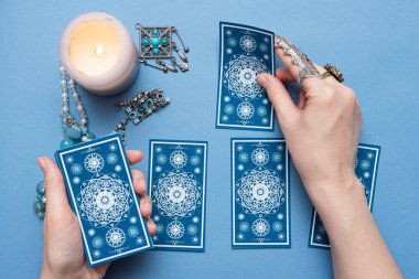 Falcı elinde tarot kartları tutuyor..