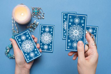 Falcı elinde tarot kartları tutuyor..