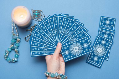 Falcı elinde tarot kartları tutuyor..