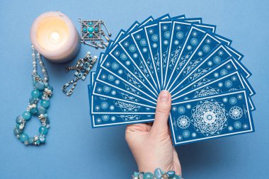 Falcı elinde tarot kartları tutuyor..