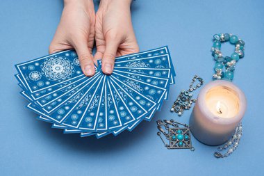 Falcı elinde tarot kartları tutuyor..