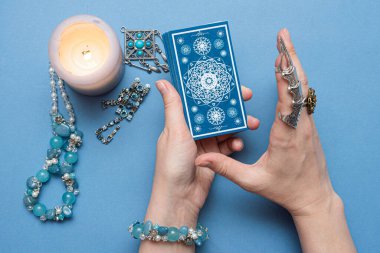 Falcı elinde tarot kartları tutuyor..