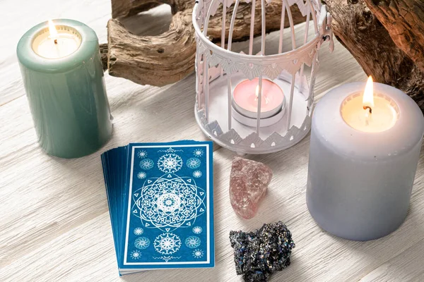 Beyaz ahşap masa arkasında mavi tarot kartları.