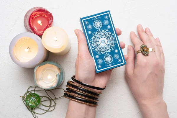 Falcı beyaz masa arka planında tarot kartlarında geleceği okuyor.
