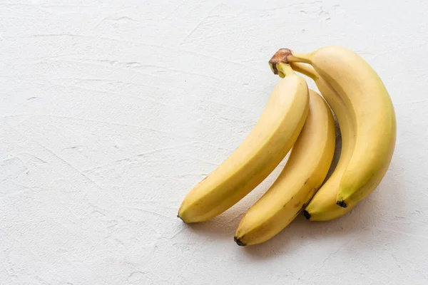 stock image Pile of ripe bananas on a white table background with copy space.