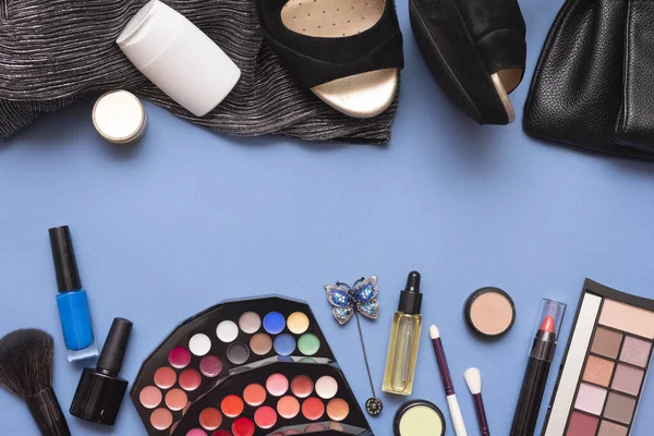 Beauty make up accessories on the blue flat lay background with copy space.