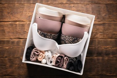 Beyaz bir konteynır kutusundaki kadın iç çamaşırı ahşap düz bir tezgahta duruyordu..