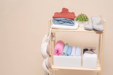 Giysi dolabında giysi rafı ve raflarda depolama kutusu var. Arka planda fotokopi alanı var..