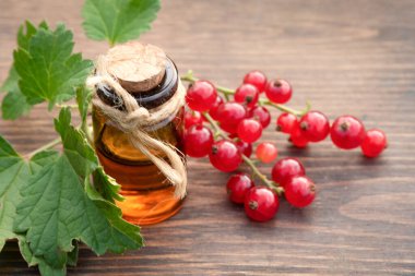 Ahşap bahçe arka planında kırmızı frenk üzümü yağı..