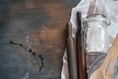 Cam kavanozda un, merdane, süzgeç ve havlu var. Arka planda fotokopi alanı var..