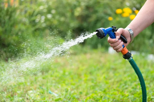 Gärtner Gießt Gartenbeet Mit Wassersprenger Aus Nächster Nähe — Stockfoto