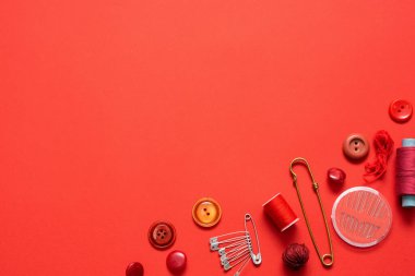 Kırmızı düz zemin üzerinde aksesuarlar dikiliyor.