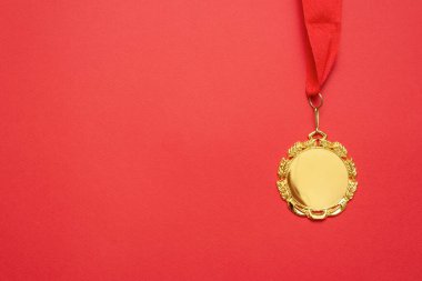 Kırmızı arkaplanda kopyalama alanı olan altın madalyalar.