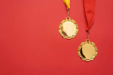 Kırmızı arkaplanda kopyalama alanı olan altın madalyalar.
