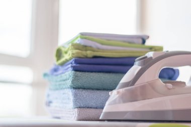 Ütü masasındaki havlu yığını ve ütü masasının arkasını kapatın.