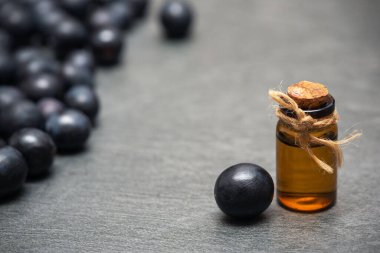 Üzüm ve üzüm suyu, gri masa arkaplanında fotokopi alanı ile gerekli yağ suyu..