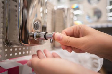 Kadın bir mağazadan yeni bir sabun makinesi seçiyor..