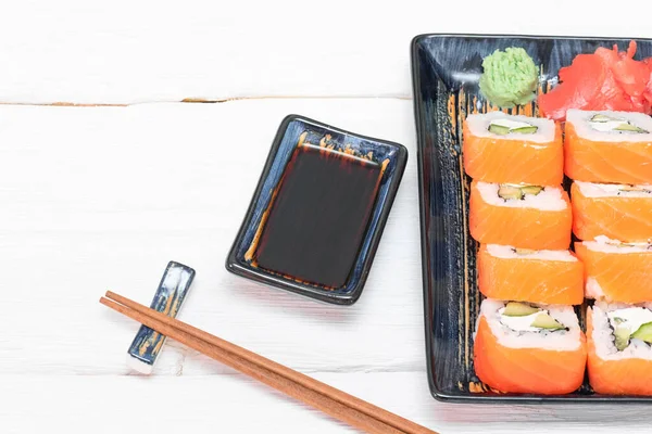 Beyaz arka planda suşi ruloları ve soya sosu..