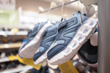 Çocuk ayakkabıları mağazanın rafında asılı. Yakından..