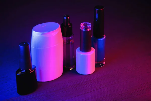 Nagellackflaschen Auf Dem Tisch Neonlicht Hintergrund — Stockfoto