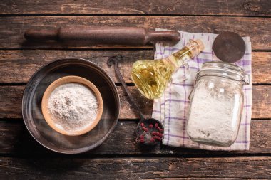 Kavanozda un, süzgeç, pompa ve mutfak masasının arka planında pişirme yağı..