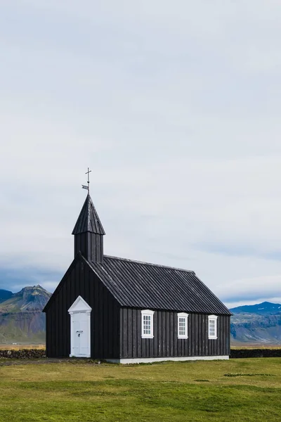Igreja negra no prado e campo na Islândia. Islandês destino de viagem cênica de religião . — Fotografia de Stock