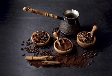 Kahve, kahve çekirdekleri, anason, siyah arka plan üzerine tarçın.