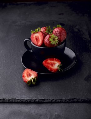 Siyah taş arka planda siyah bardak çilek