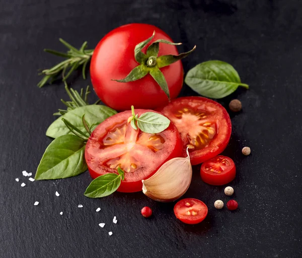 Frische Basilikumblätter Mit Tomaten Rosmarin Und Knoblauch Auf Schwarzem Stein Stockfoto