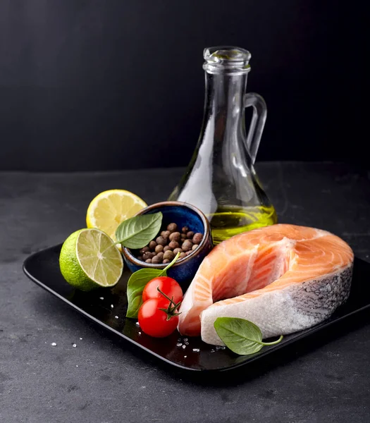 Lachsfisch Auf Dem Schwarzen Teller Mit Frischen Basilikumblättern Zitrusfrüchten Olivenöl Stockbild