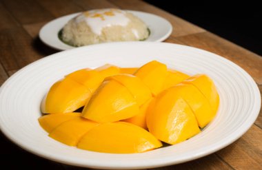 Mango ve ahşap zemin, Tay tatlı Tayland yazında popüler üzerinde beyaz tabak içinde yapışkan pirinç