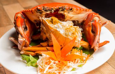 Yengeç ya da haşlanmış yengeç Yengeç'ın spawn beyaz tabak lezzetli yengecin yumurta kabuğu içinde ahşap masa üzerinde gösterilen ile taze haşlanmış. Tay deniz ürünleri.