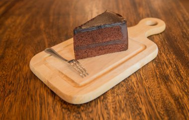 Frok tarihinde ahşap masa ile çikolatalı pasta dilimi kapatın.