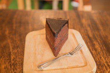 Frok tarihinde ahşap masa ile çikolatalı pasta dilimi kapatın.