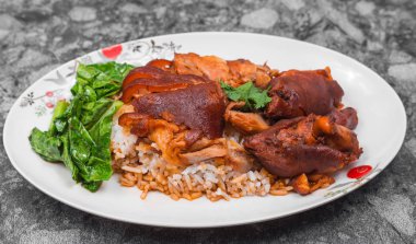 Alman domuz knuckle pirinç, sebze ve meyve ile ahşap masa sosu ile servis.