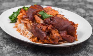 Alman domuz knuckle pirinç, sebze ve meyve ile ahşap masa sosu ile servis.