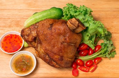 Doğrama kurulu ve ahşap masa soslu domuz knuckle veya Alman domuz hocks sebze ve meyve servis.