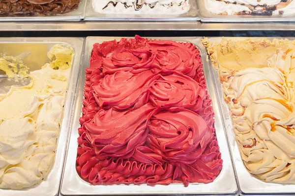 Trays of different types of ice cream in a shop - gelaterie artigianali - in Italy. Sale, consumerism, summer and people concept